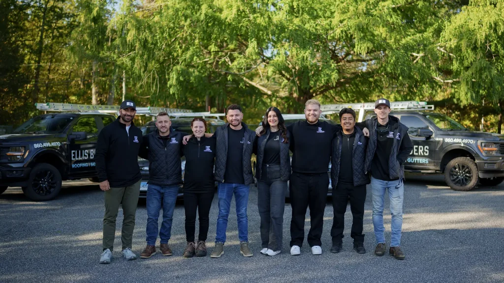 Ellis Builders LLC roofing crew smiling in front of company trucks in Southbury Connecticut.
