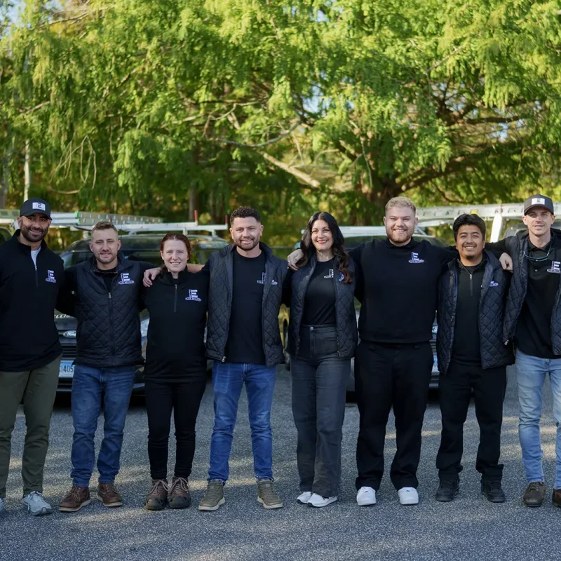 Ellis Builders LLC roofing crew smiling in front of company trucks in Southbury Connecticut.